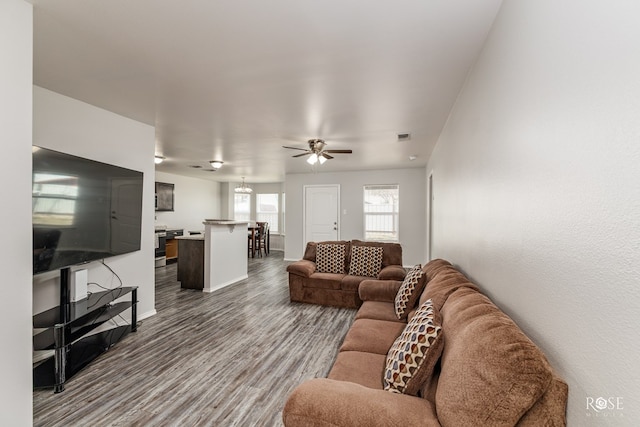 living room featuring dark wood-style floors, baseboards, and a ceiling fan