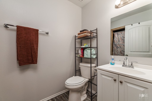 bathroom featuring baseboards, toilet, a shower with curtain, wood finished floors, and vanity