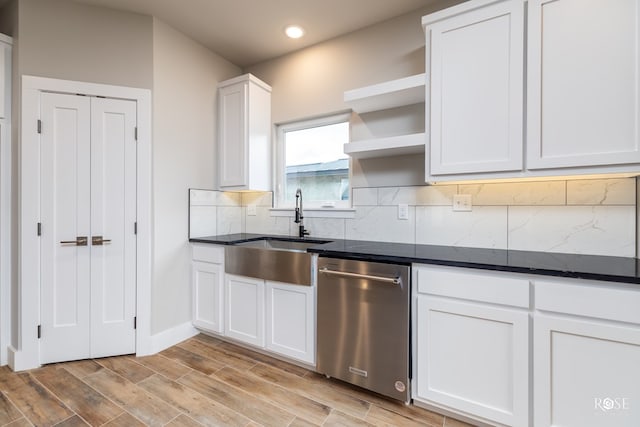 kitchen with white cabinetry, stainless steel dishwasher, sink, and backsplash