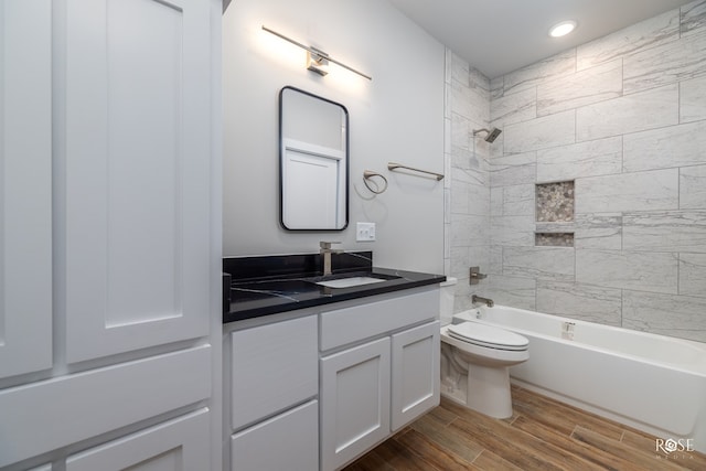 full bathroom with vanity, tiled shower / bath combo, and toilet