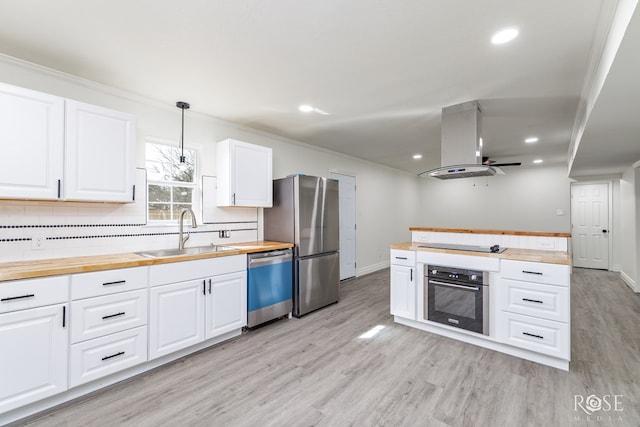4815 Bowie St, San Angelo, TX 76903 - kitchen with butcher block counters, appliances with stainless steel finishes, a sink, island range hood, and light wood-type flooring