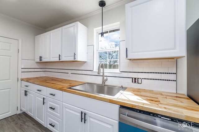 4815 Bowie St, San Angelo, TX 76903 - kitchen with butcher block countertops, a sink, dishwasher, crown molding, and white cabinets