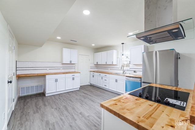 4815 Bowie St, San Angelo, TX 76903 - kitchen featuring butcher block countertops, stainless steel appliances, a sink, white cabinets, and recessed lighting