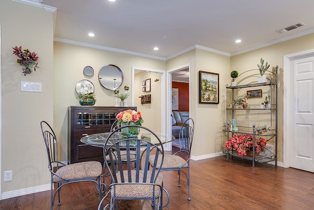 dining area with visible vents, crown molding, baseboards, and wood finished floors