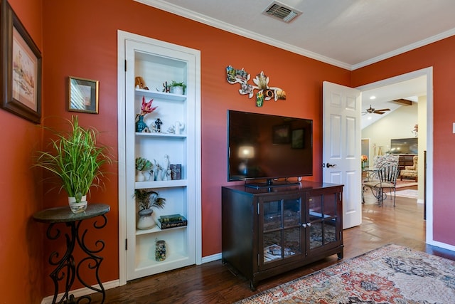 living area featuring crown molding, wood finished floors, built in features, baseboards, and visible vents