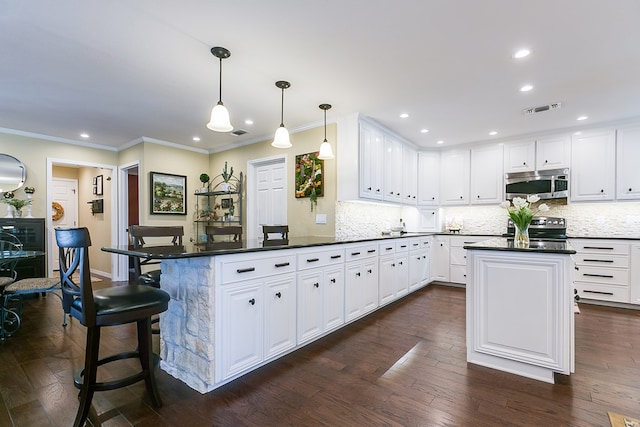 kitchen featuring visible vents, white cabinets, a peninsula, and stainless steel appliances