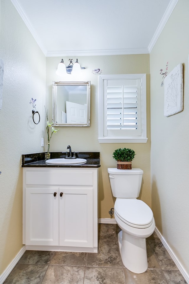 half bathroom with toilet, vanity, crown molding, and baseboards
