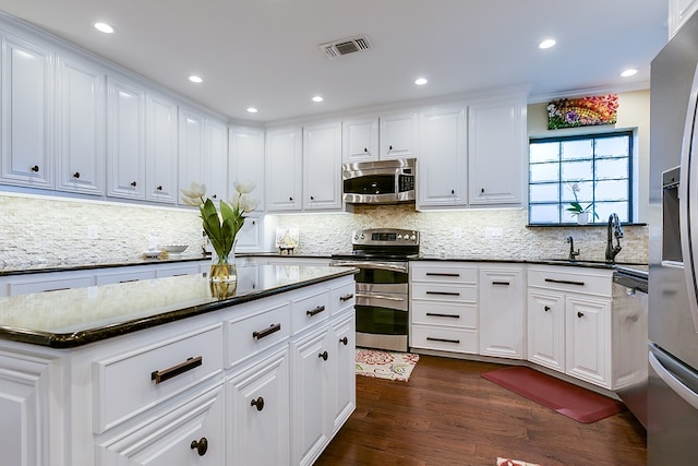 kitchen with a sink, visible vents, white cabinetry, and stainless steel appliances