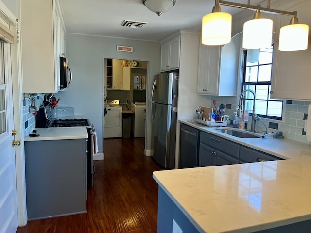 2708 A & M Ave, San Angelo, TX 76904 - kitchen featuring stainless steel appliances, washer and clothes dryer, a sink, and decorative backsplash