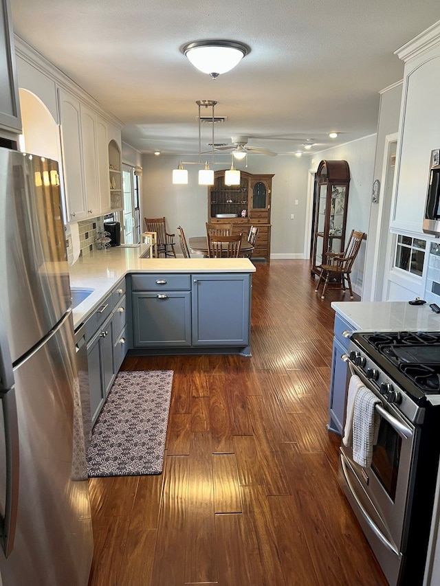 2708 A & M Ave, San Angelo, TX 76904 - kitchen with appliances with stainless steel finishes, a peninsula, dark wood-type flooring, light countertops, and ceiling fan