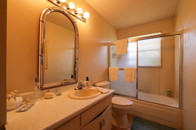 109 Live Oak Dr, Ozona, TX 76943 - bathroom with a textured ceiling, vanity, toilet, and bath / shower combo with glass door