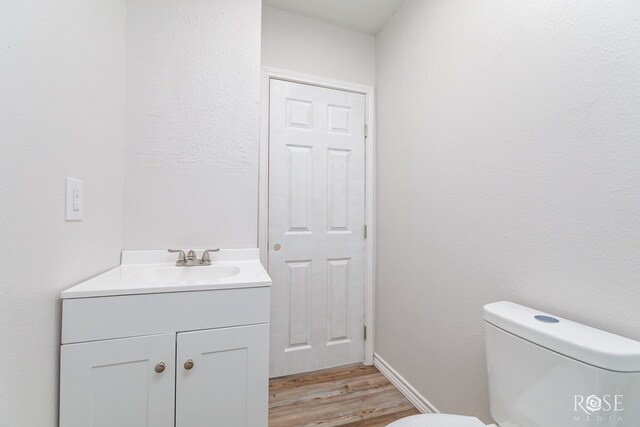 bathroom with vanity, hardwood / wood-style floors, and toilet