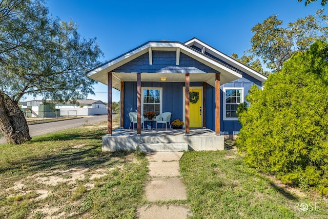 bungalow with a front yard and a porch