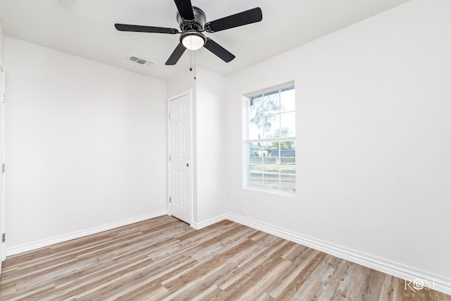 empty room with ceiling fan and light hardwood / wood-style flooring