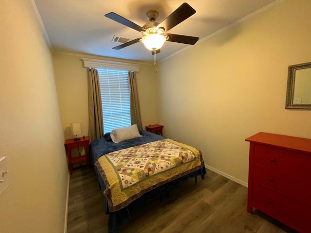 bedroom featuring visible vents, crown molding, baseboards, and wood finished floors