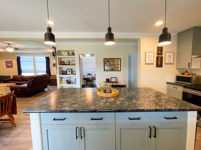 kitchen featuring pendant lighting, light wood-style flooring, appliances with stainless steel finishes, ornamental molding, and a ceiling fan