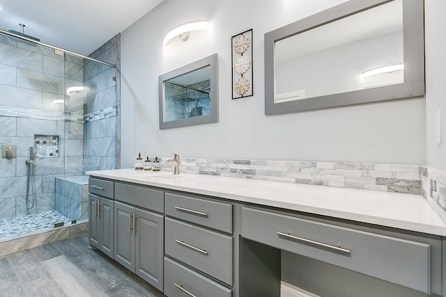 bathroom with vanity, wood-type flooring, and a tile shower