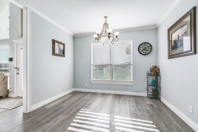 unfurnished dining area featuring an inviting chandelier, ornamental molding, and dark hardwood / wood-style floors