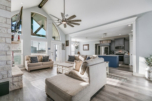 living room featuring crown molding, high vaulted ceiling, light hardwood / wood-style flooring, beamed ceiling, and ceiling fan with notable chandelier