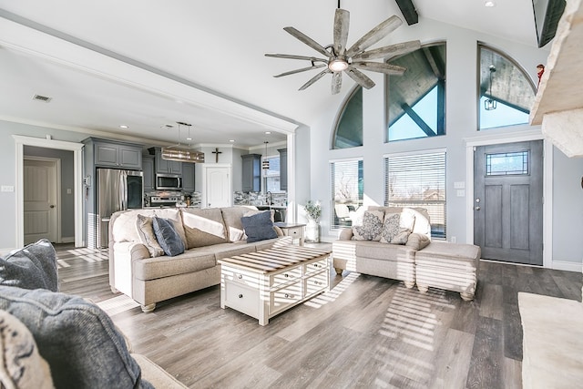 living room with hardwood / wood-style flooring, crown molding, high vaulted ceiling, and beamed ceiling