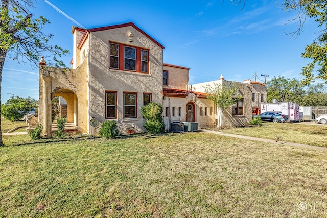 mediterranean / spanish home featuring a front lawn and central air condition unit