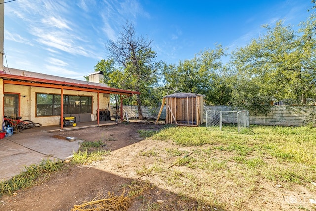 view of yard with a storage unit and a patio area