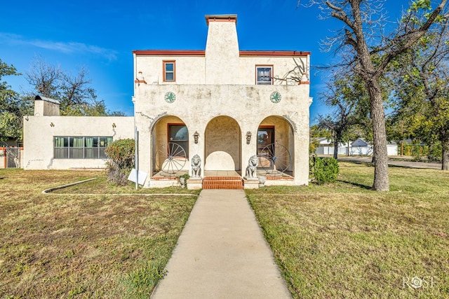 mediterranean / spanish home featuring a front lawn