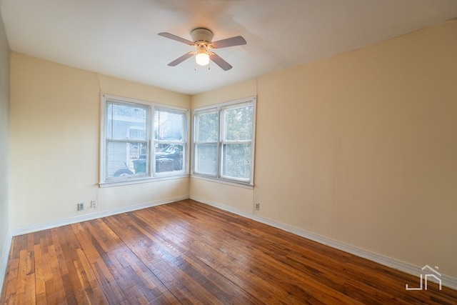 spare room with dark hardwood / wood-style flooring and ceiling fan