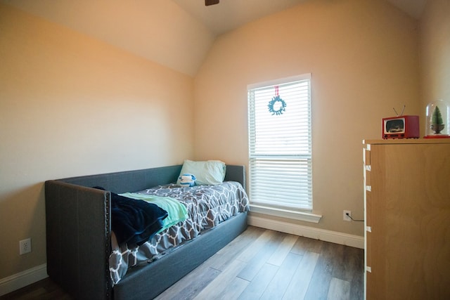 bedroom with wood-type flooring and vaulted ceiling