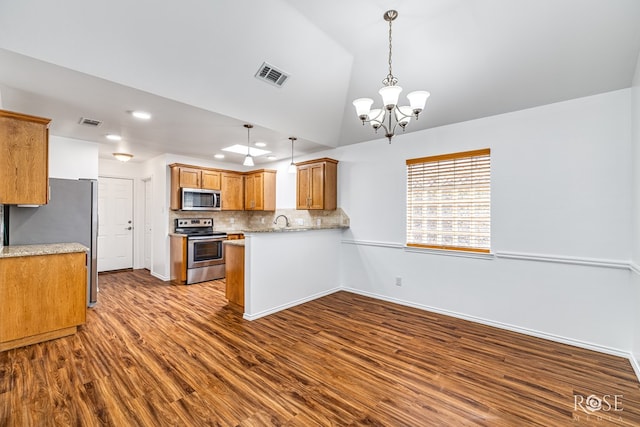 4129 Sedona Trl, San Angelo, TX 76904 - kitchen featuring stainless steel appliances, dark wood-type flooring, brown cabinets, decorative backsplash, and a chandelier