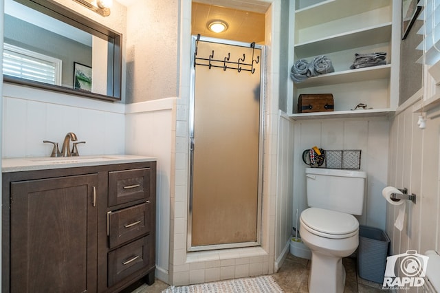 bathroom with vanity, a shower with shower door, and toilet