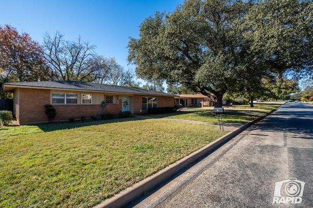 ranch-style home featuring a front lawn