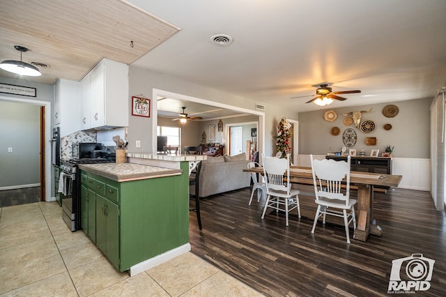 kitchen featuring white cabinetry, stainless steel range with gas cooktop, ceiling fan, and green cabinets