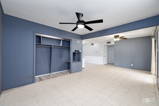 3109 College Hills Cir, San Angelo, TX 76904 - unfurnished living room featuring a decorative wall, a ceiling fan, and light tile patterned floors