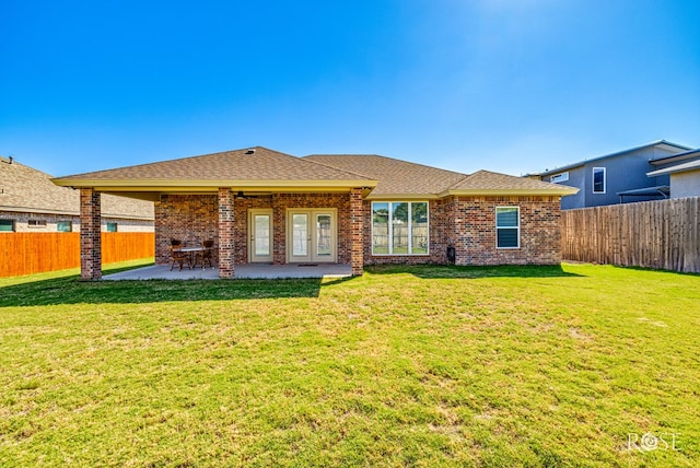 rear view of house with a patio area and a lawn