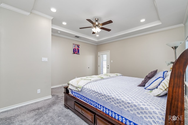 bedroom featuring a tray ceiling, light colored carpet, ornamental molding, and ceiling fan