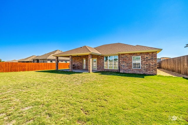 rear view of house with a patio and a lawn