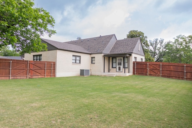 1905 Live Oak St, San Angelo, TX 76901 - rear view of house featuring a fenced backyard, a yard, brick siding, and central AC unit