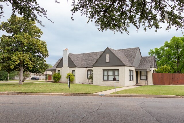 1905 Live Oak St, San Angelo, TX 76901 - view of front of property featuring a chimney, a front yard, a shingled roof, and fence