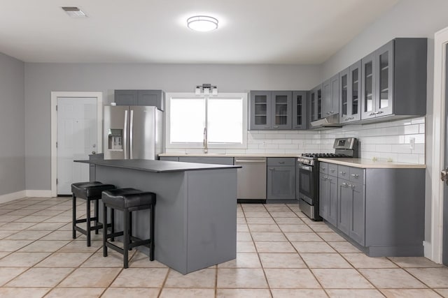 1905 Live Oak St, San Angelo, TX 76901 - kitchen with a breakfast bar, gray cabinets, visible vents, appliances with stainless steel finishes, and light tile patterned flooring