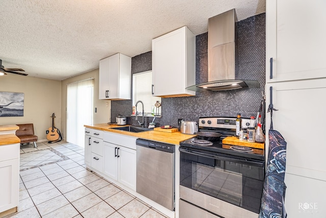 705 Fay St, Sonora, TX 76950 - kitchen with stainless steel appliances, wall chimney exhaust hood, butcher block counters, backsplash, and a textured ceiling
