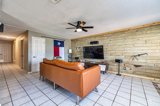 705 Fay St, Sonora, TX 76950 - living area with ceiling fan, light tile patterned floors, wooden walls, and a textured ceiling