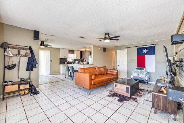 705 Fay St, Sonora, TX 76950 - living area featuring a ceiling fan, light tile patterned floors, and a textured ceiling