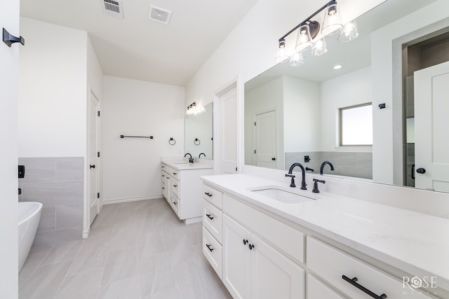 bathroom featuring two vanities, a sink, and visible vents