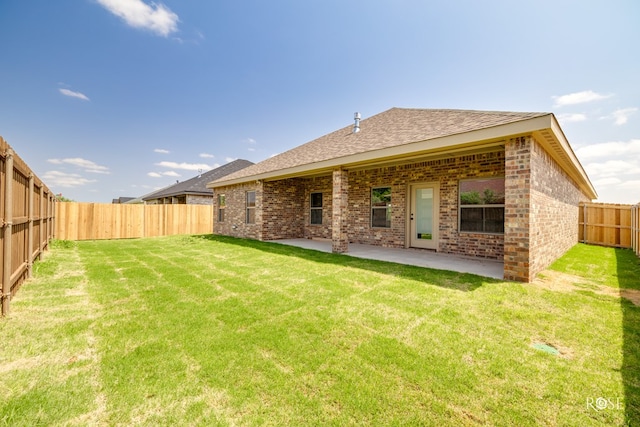 5441 Riviera Ln, San Angelo, TX 76904 - back of property featuring a yard, a patio area, brick siding, and a fenced backyard