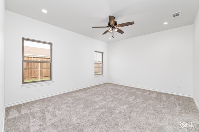 empty room with recessed lighting, light colored carpet, visible vents, ceiling fan, and baseboards