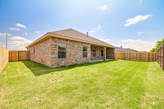 5441 Riviera Ln, San Angelo, TX 76904 - back of property featuring roof with shingles, a yard, brick siding, and a fenced backyard