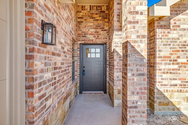 property entrance featuring brick siding