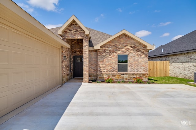 5441 Riviera Ln, San Angelo, TX 76904 - view of front of house with stone siding, brick siding, fence, and roof with shingles