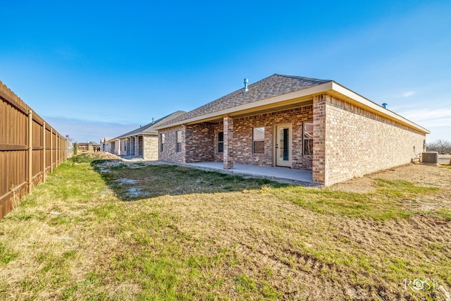 back of house with a yard, a fenced backyard, a patio, and brick siding